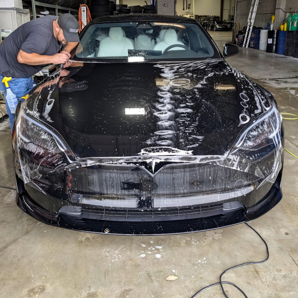 Paint protection film being applied to a Tesla.